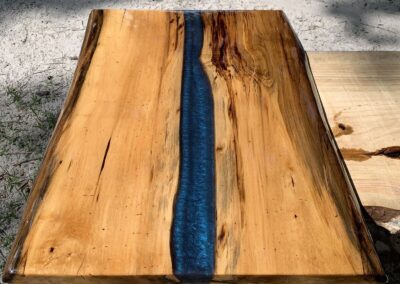 coffee table top made with spalted magnolia wood and blue epoxy resin.