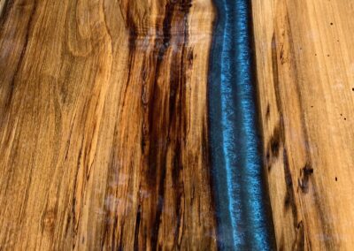 coffee table top made with spalted magnolia wood and blue epoxy resin.